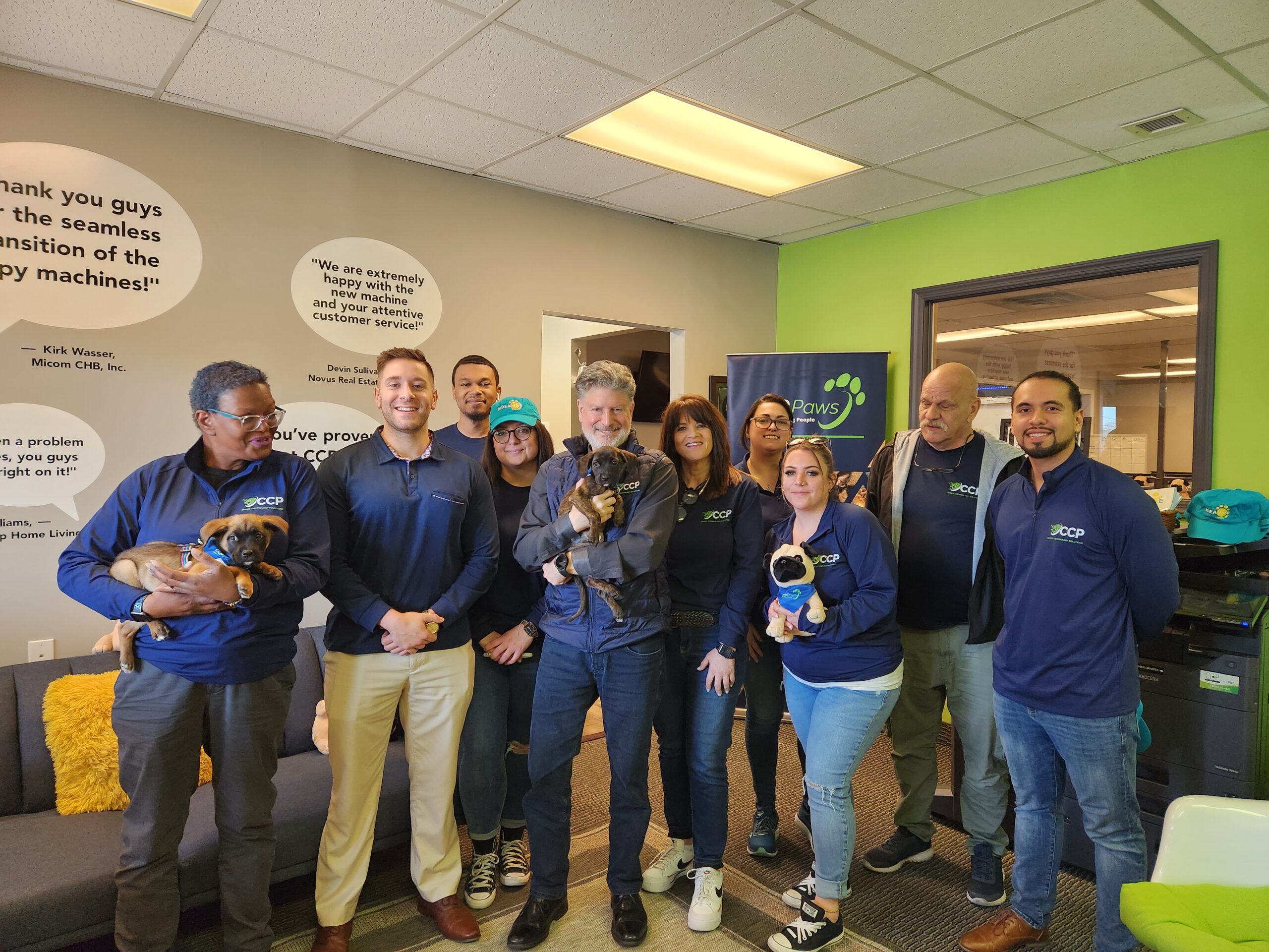 group photo of people holding puppies