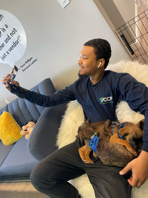 man taking a selfie with a puppy laying in his lap